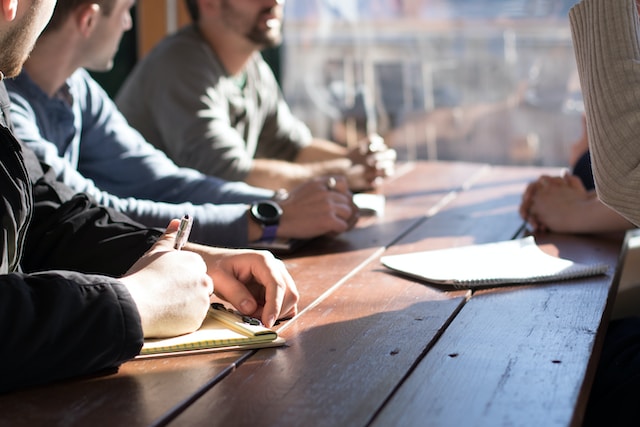 7 real estate syndication team members sitting at a table underwriting another investment property