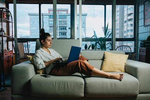 real estate syndication investor learning about cap rates sitting on a couch working on her laptop