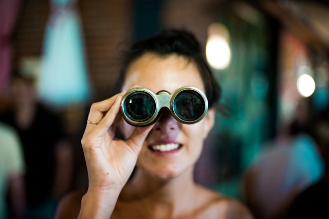 real estate syndication investor looking through binoculars to Find Off-Market or Out-of-State Commercial Real Estate Deals