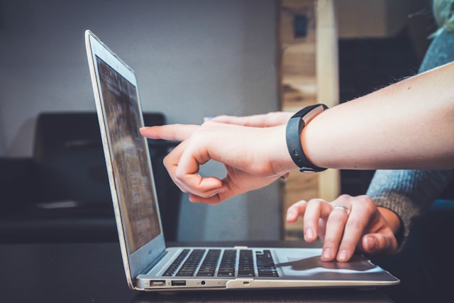 two real estate syndication investors reviewing the returns of a deal on a laptop