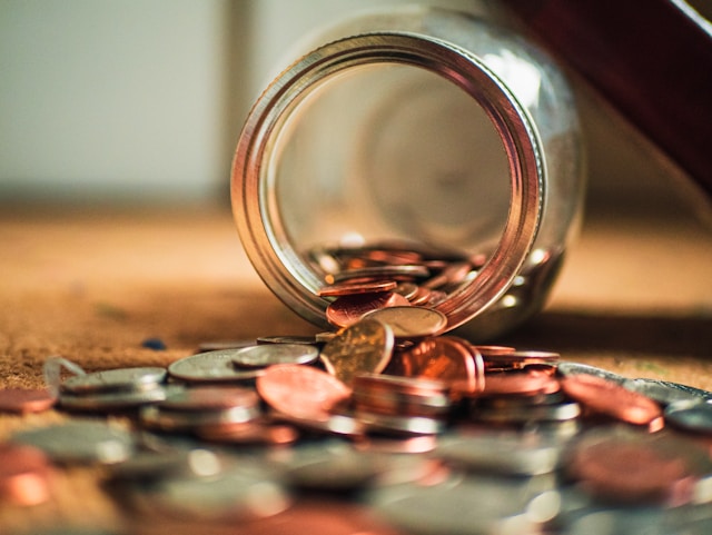 pennies fallout out of a tipped over jar